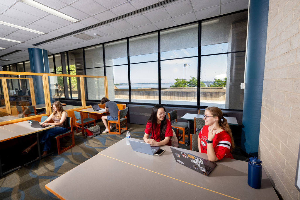 Students use laptops and course materials during a drop-in chemistry tutoring session.